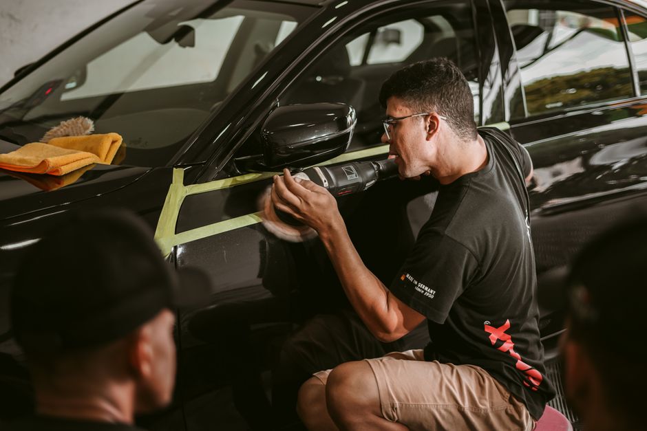 Professional detailer polishing a vehicle's exterior